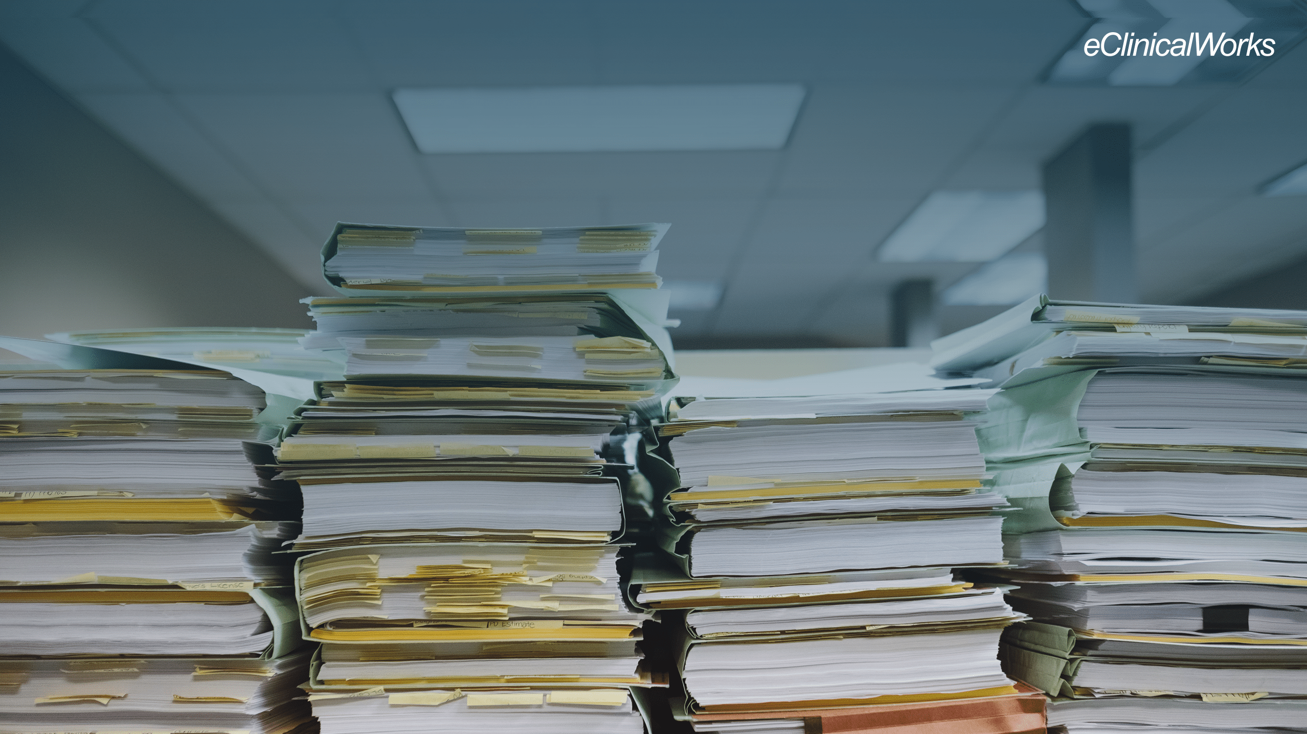 stack of books with sticky notes and files with a blue gradient on the top half of the image and the eClinicalWorks logo in the upper right hand side in white text