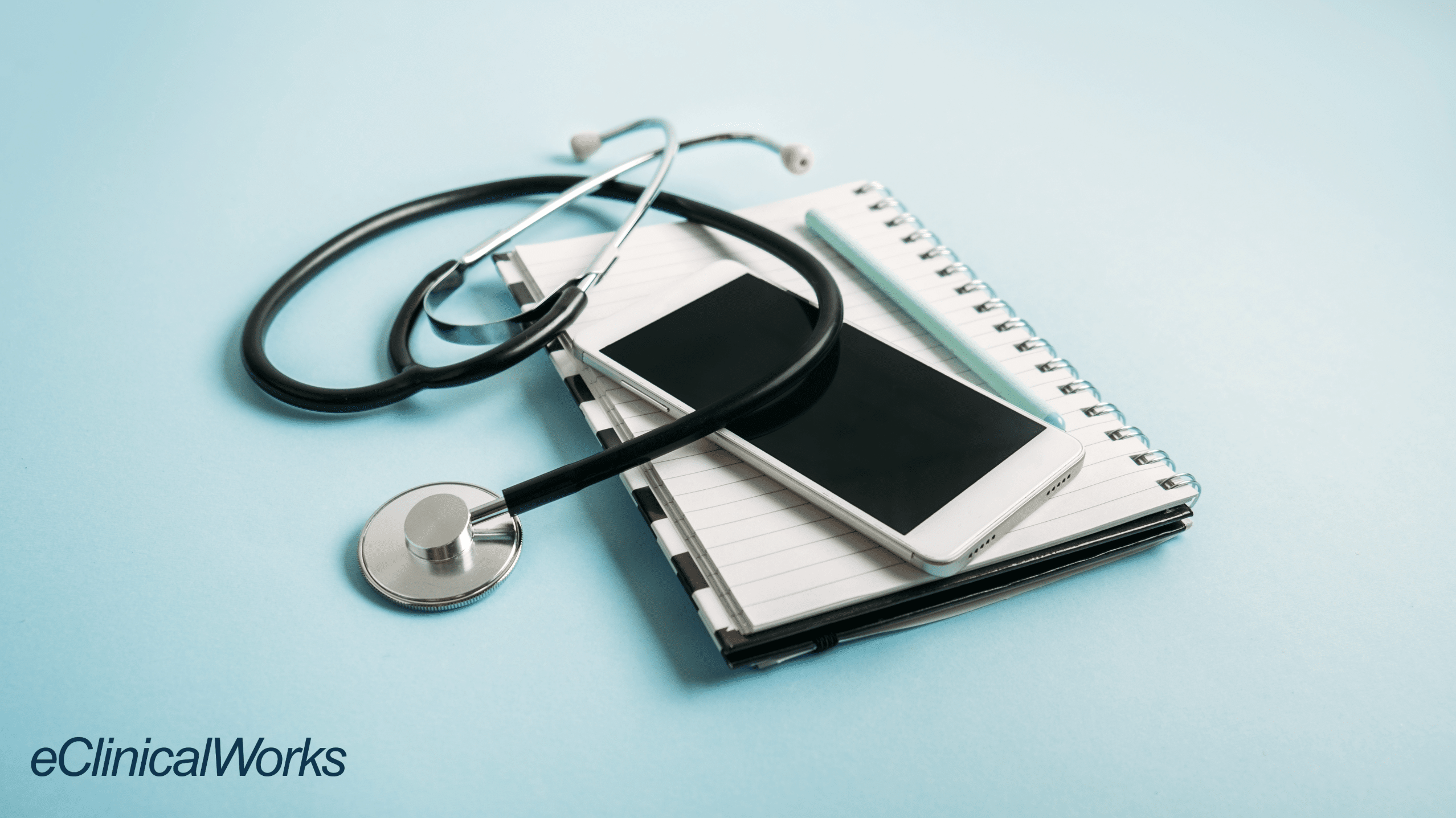 phone on top of notebook and stethoscope on top of mobile phone