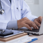 doctor typing on a laptop computer